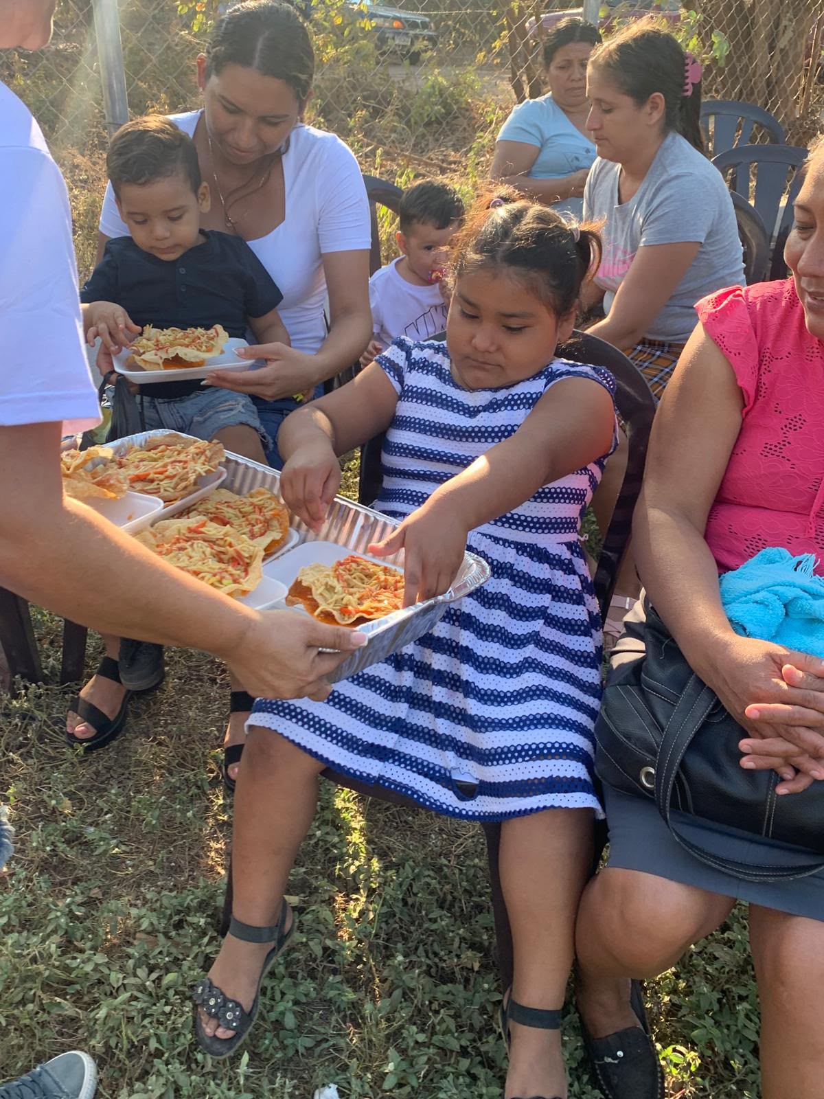 Voluntaria sirviendo comida a una nina